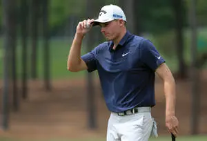 Pro Golfer Aaron Wise holding his cap in a contemplative moment