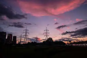a pink sky with power lines and clouds