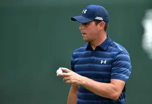 Gary Woodland proudly holding a golf ball during a tournament